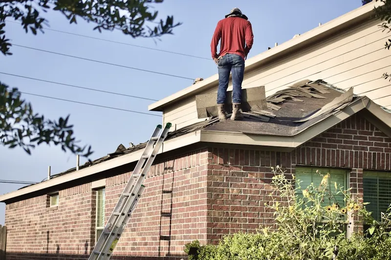 Professional roofer working on a residential roof in Miquon